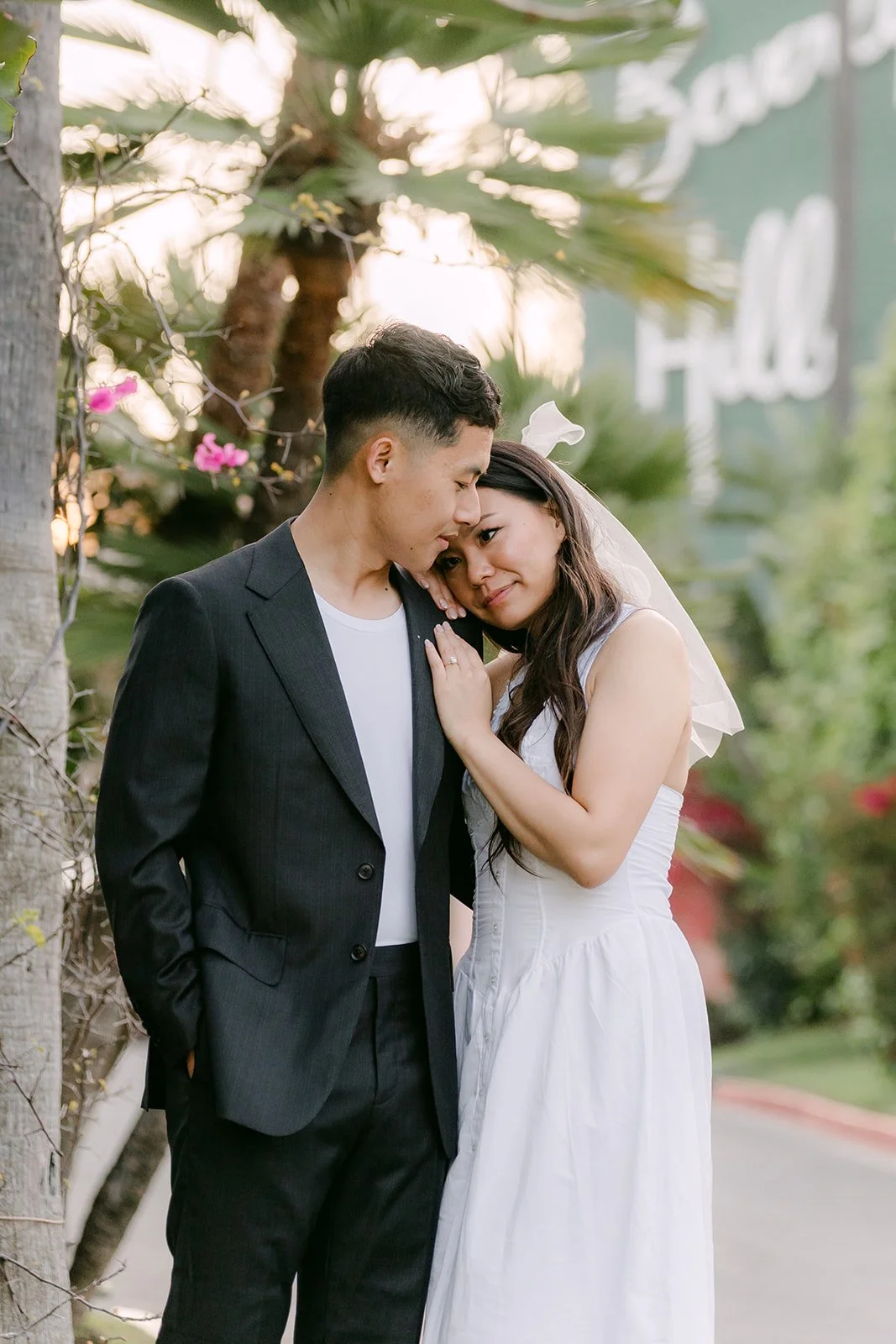 Jadee leans on Richard's shoulder in front of the hotel's green wall.