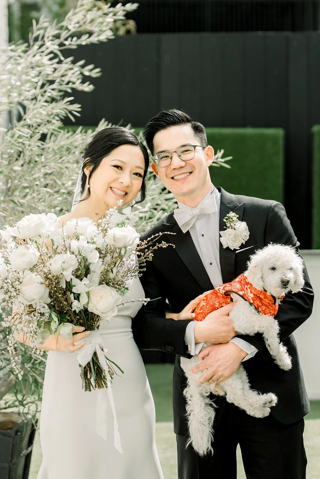 Cindy and Alex with the fluffy white dog in its red outfit
