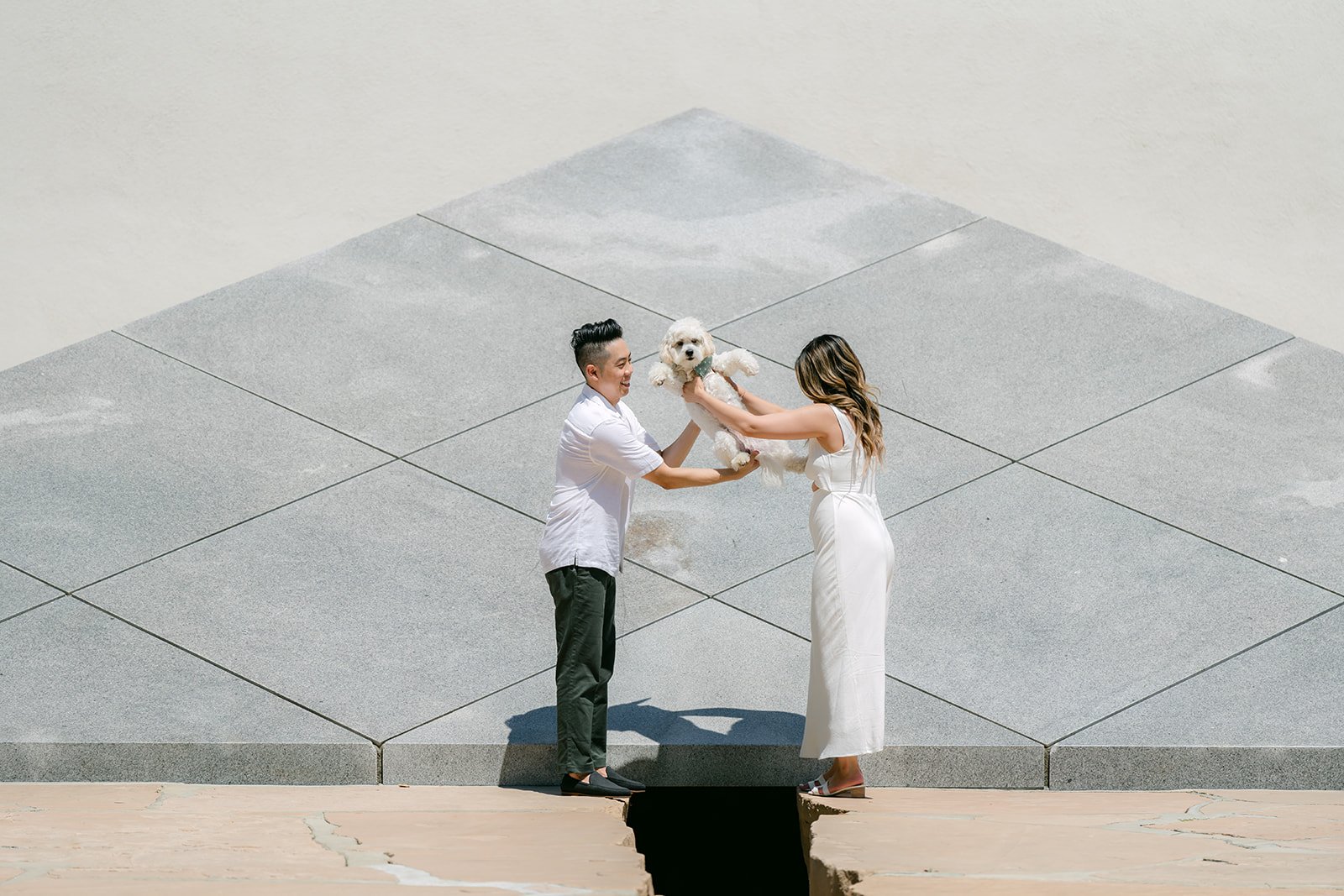 Alan and Stephanie lift Tofu in front of the granite pyramid.