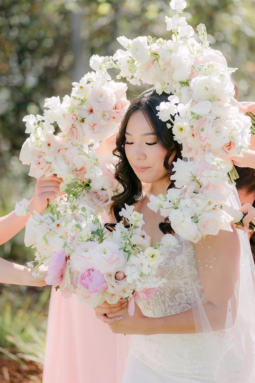 Kelli in the middle of her bridesmaids' ivory and blush bouquets