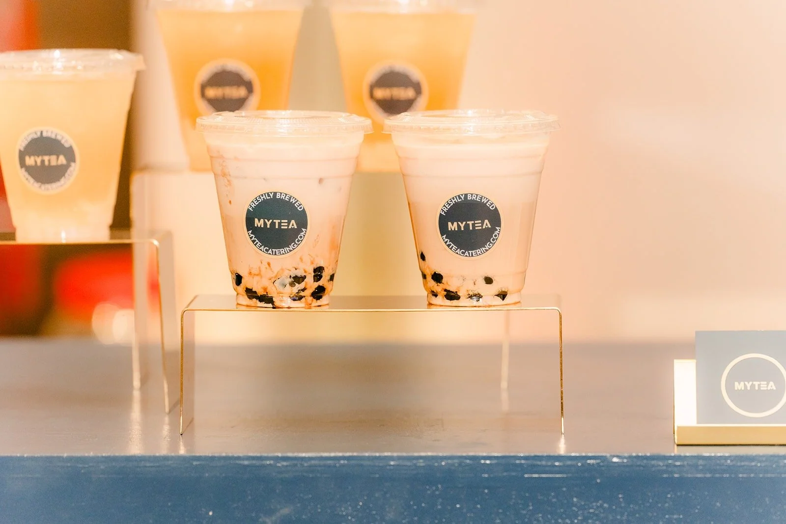 Cups of milk tea with boba and fruit teas lined up at the My Tea boba bar