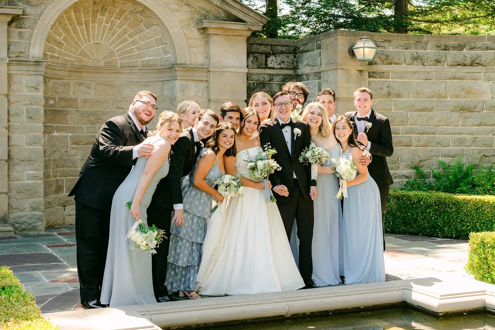 Wedding party cheering by the stone pavilion