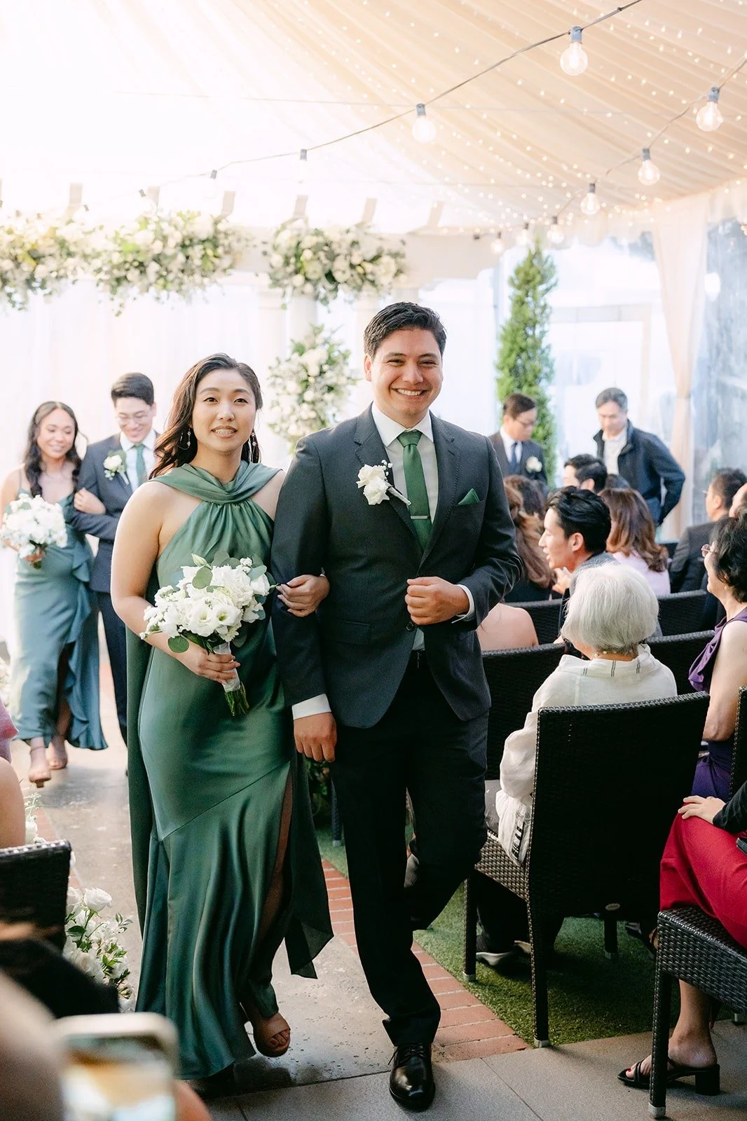 A bridesmaid and groomsman following the couple out, photographed by One and Only Production