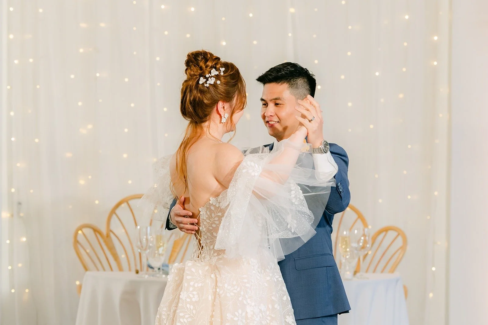 Joanna and Jerrick close together under the string lights