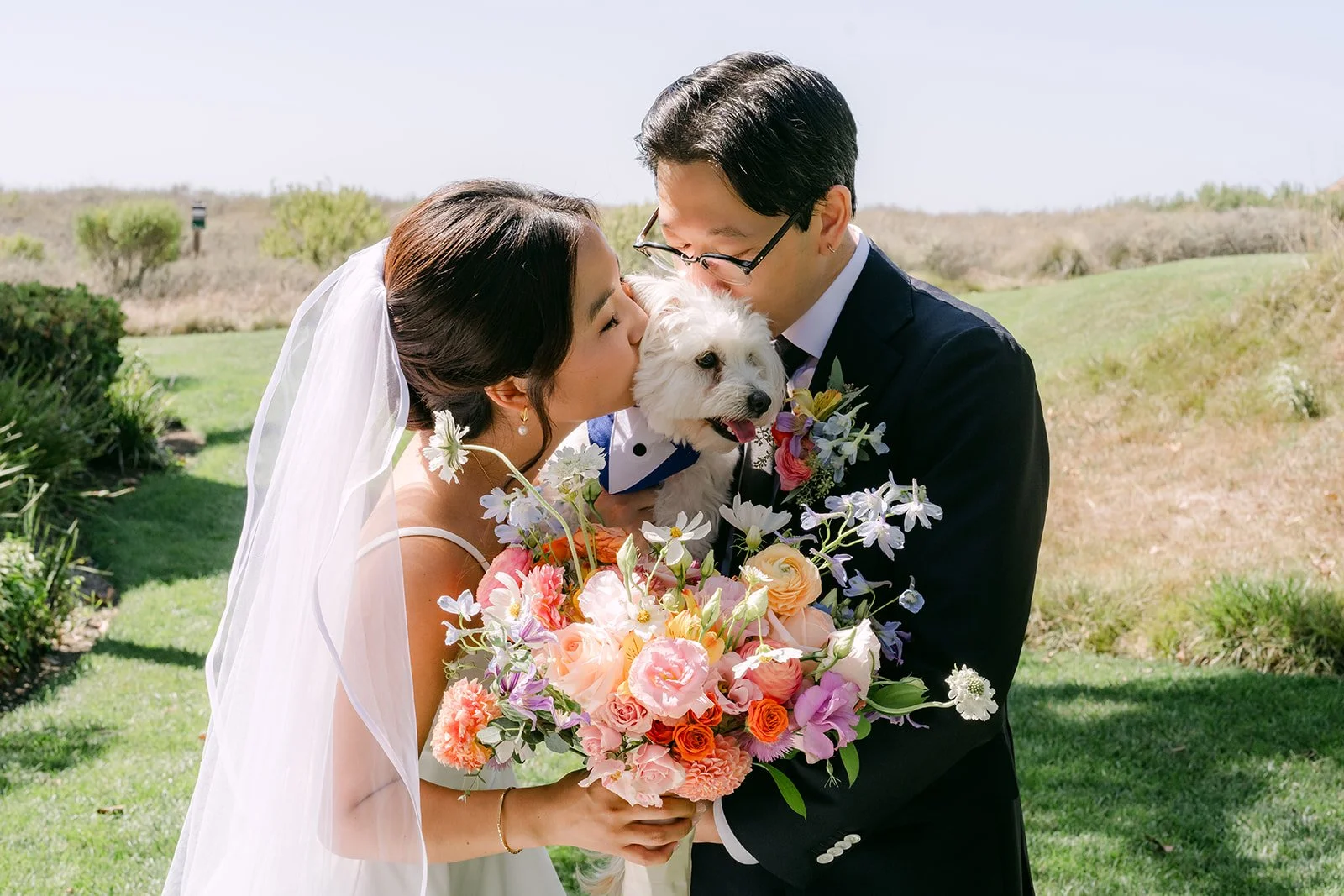 Saya and Leroy holding their dog Soup with the bouquet