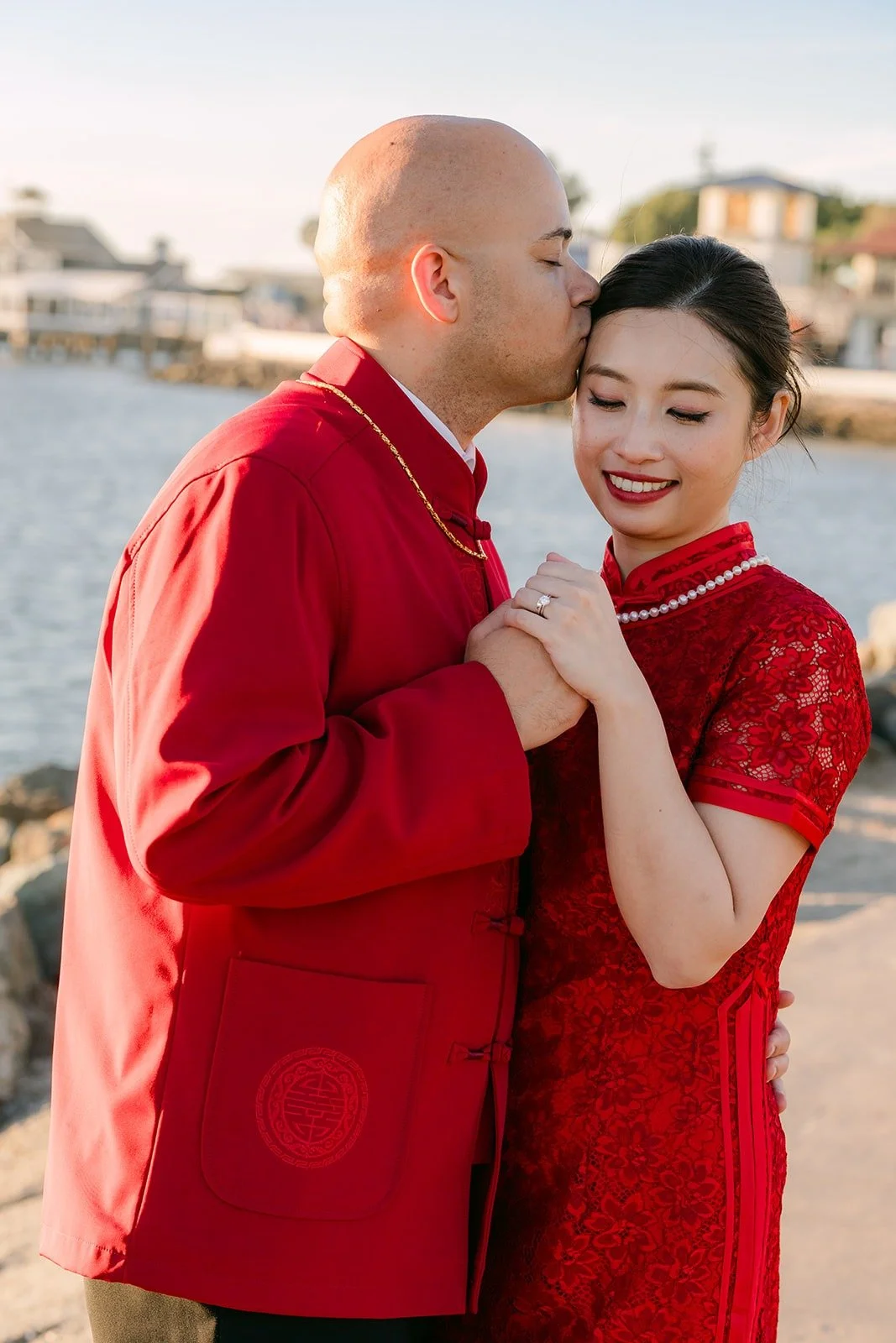 Brandon kisses Elisa on the forehead at the waterfront, photographed by One and Only Production