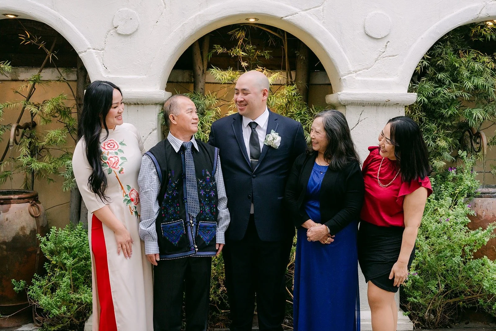 Vivian and Yao with family under the courtyard arches