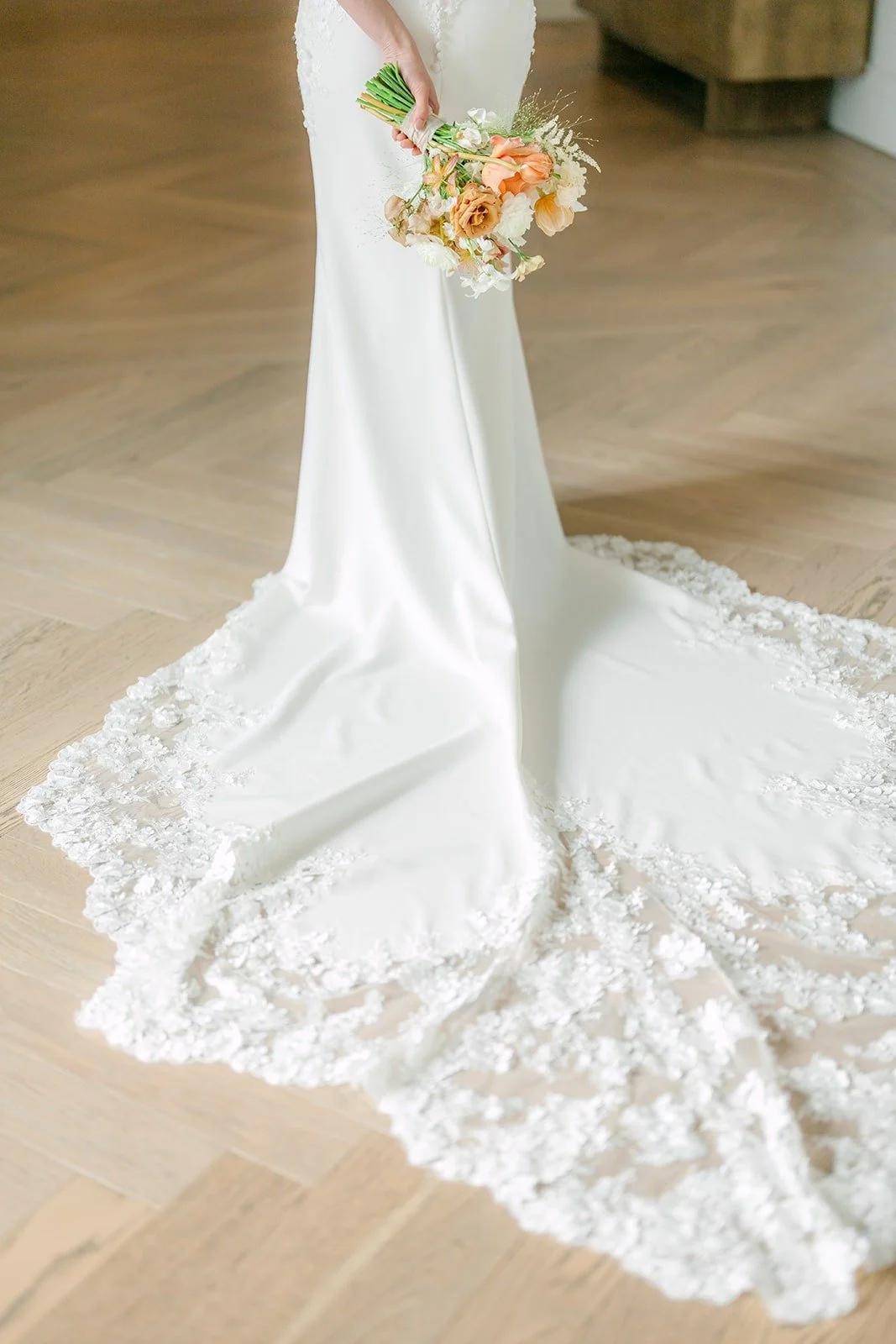 Angela's fitted gown and lace train fanned across the floor