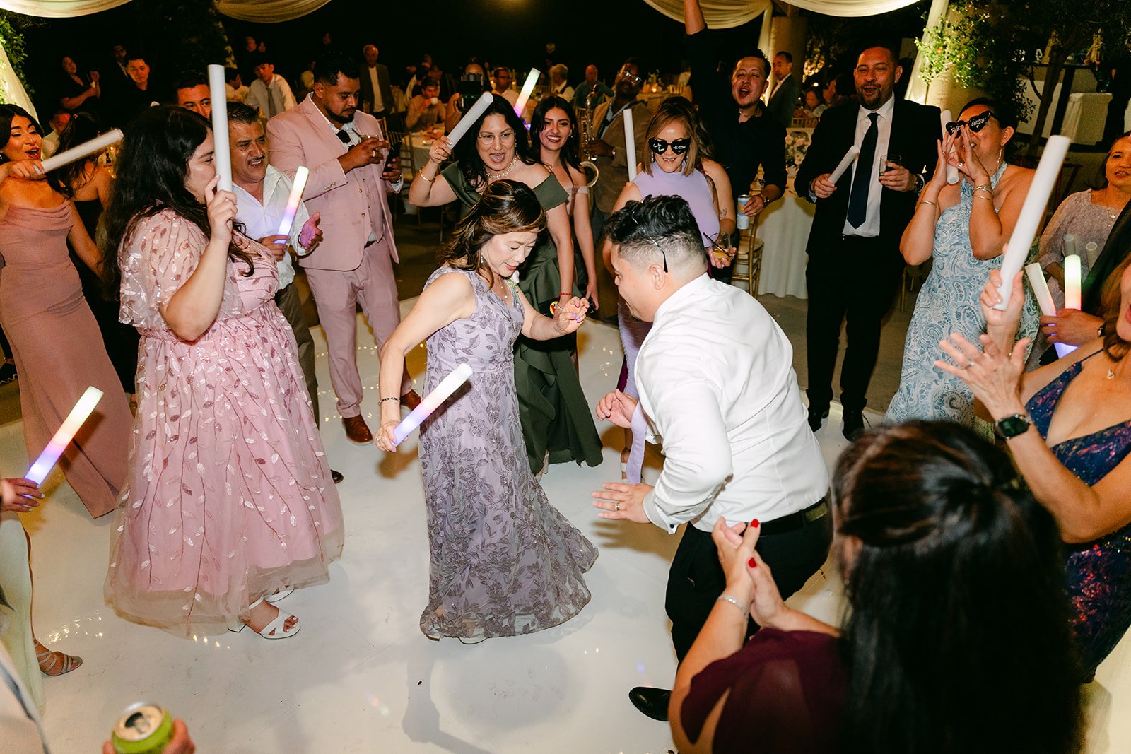 Sandra and Kevin's guests dancing with glow sticks, photographed by One and Only Production.