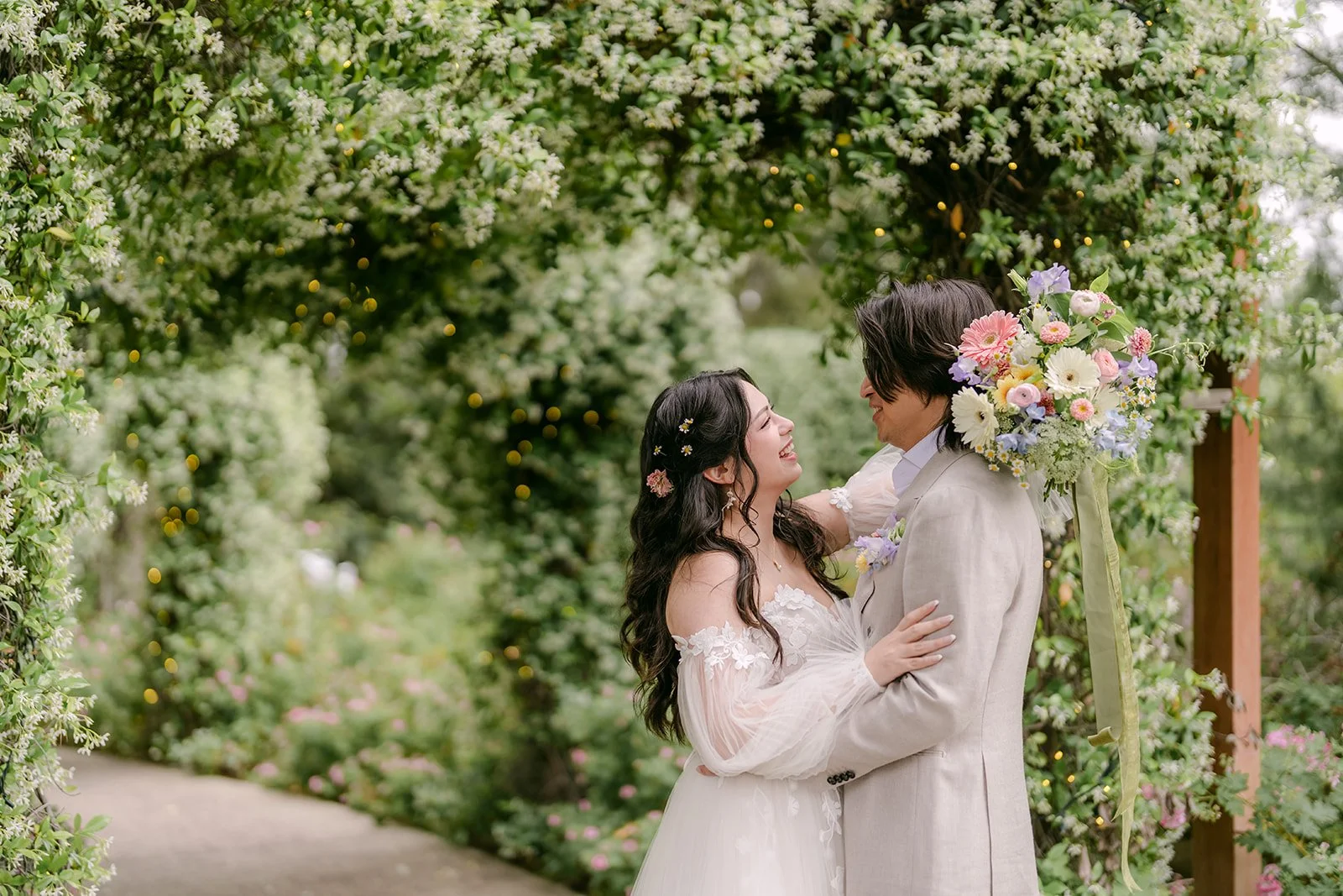 Couple embracing under the ivy arch after their first look