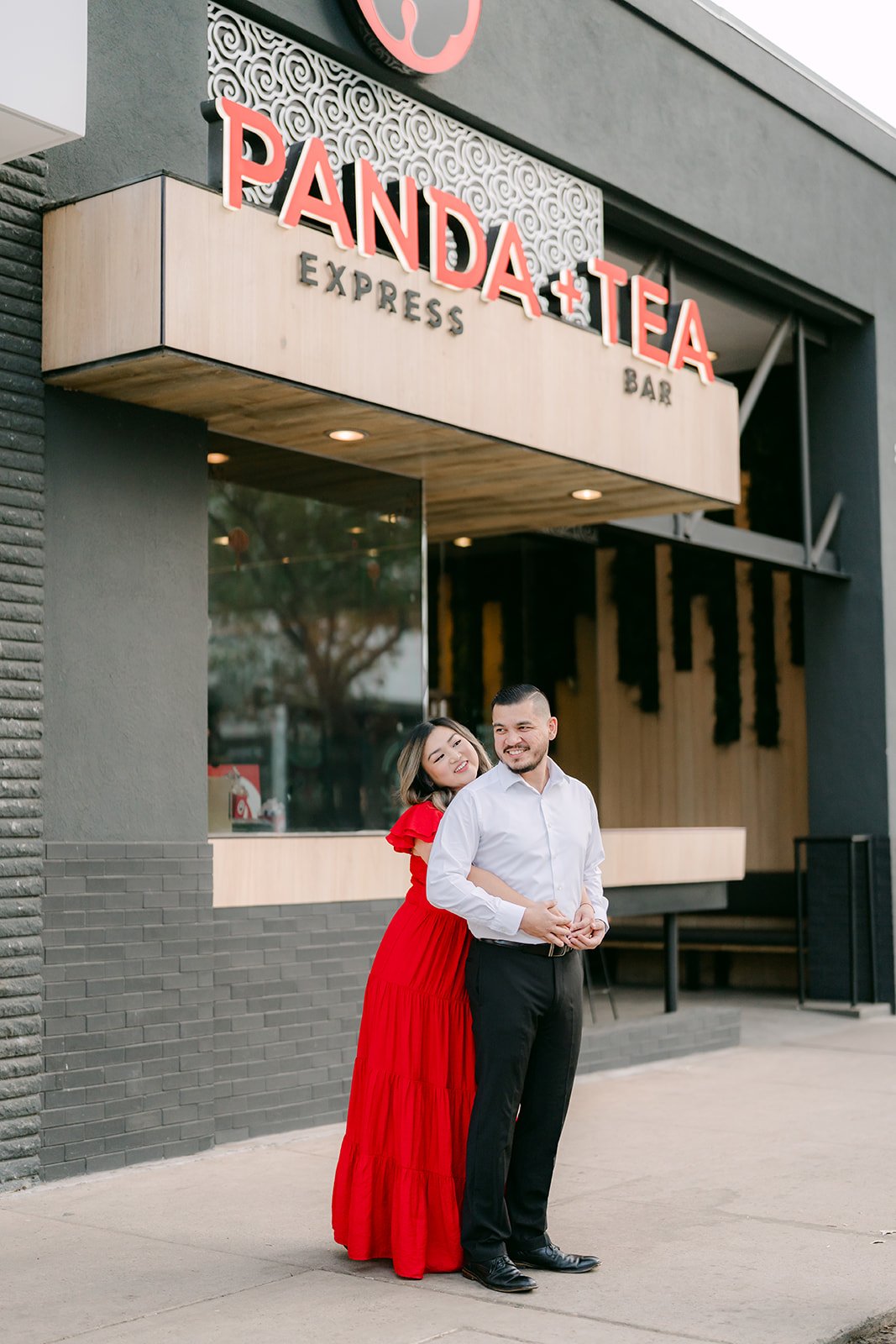 Linh and Ankush embrace beneath the Panda Express sign.