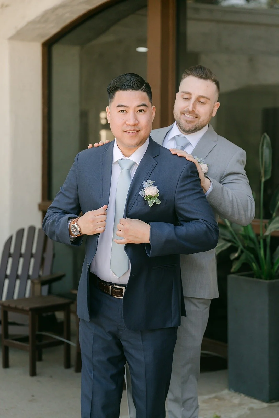 A groomsman adjusting Jordan's boutonniere