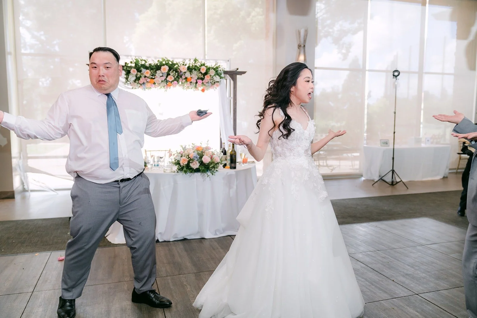 Natalie dancing with a guest in front of the sweetheart table