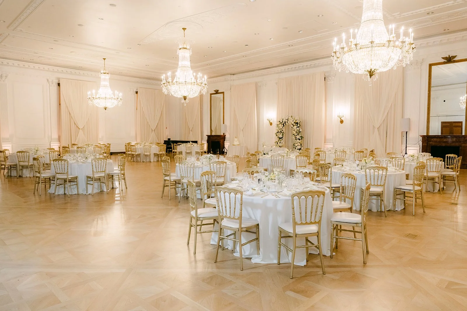 The reception ballroom at the Nixon Library with crystal chandeliers and round tables.