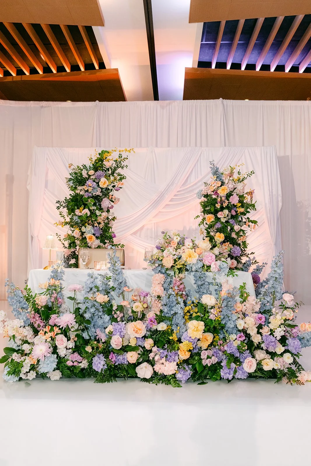 Pastel floral sweetheart backdrop at the reception