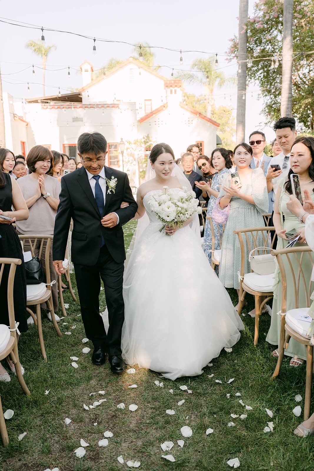 Amy walking down the aisle past standing guests