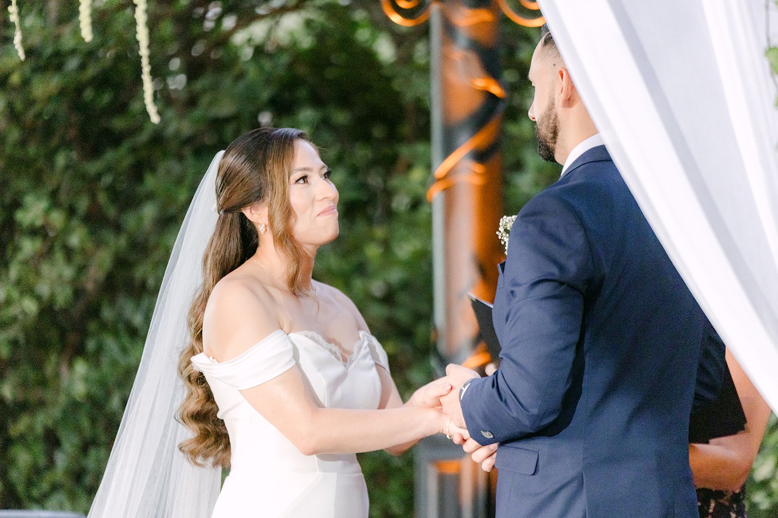 Mariana and Danny holding hands under the gazebo drapery