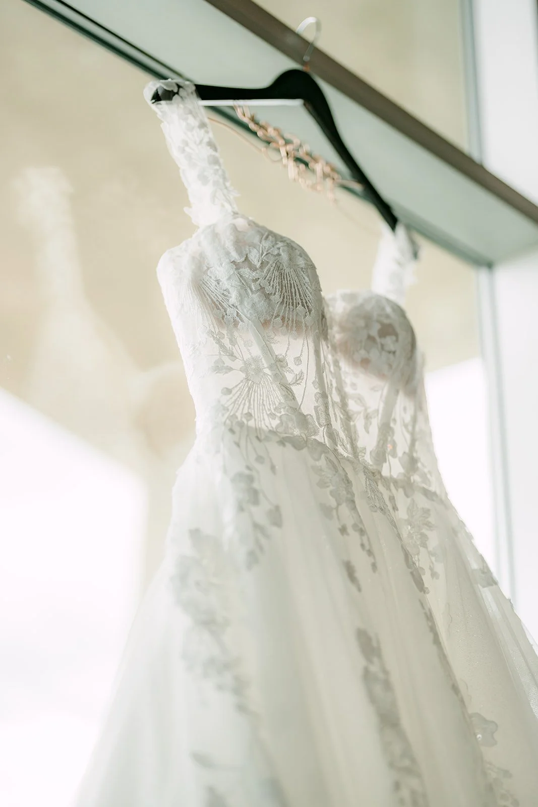 Detail of the lace bodice on Raine's wedding dress on a hanger