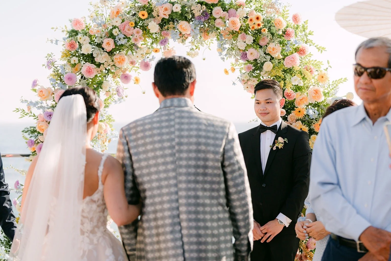 Kylie walking toward Mario with a family member at the end of the aisle