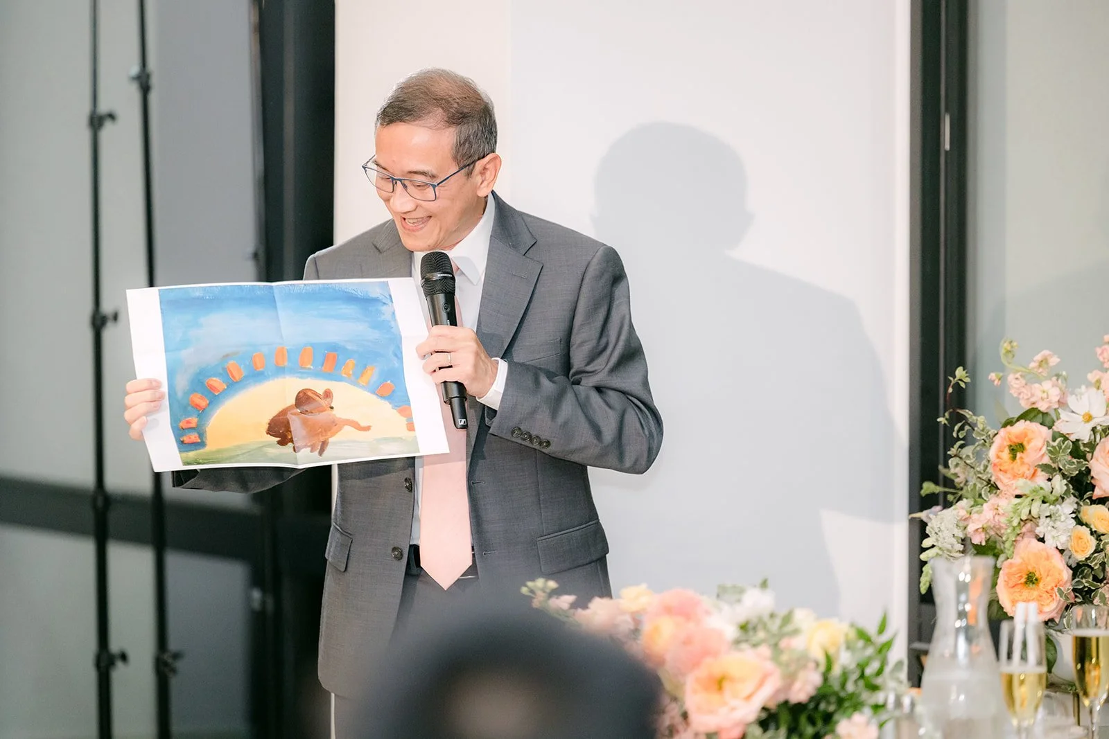 A guest holding up a photo during his toast