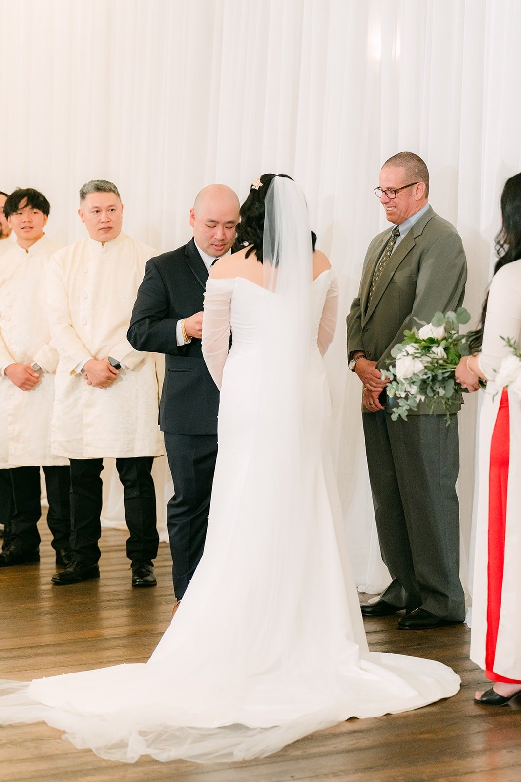 Vivian and Yao holding hands as the officiant speaks