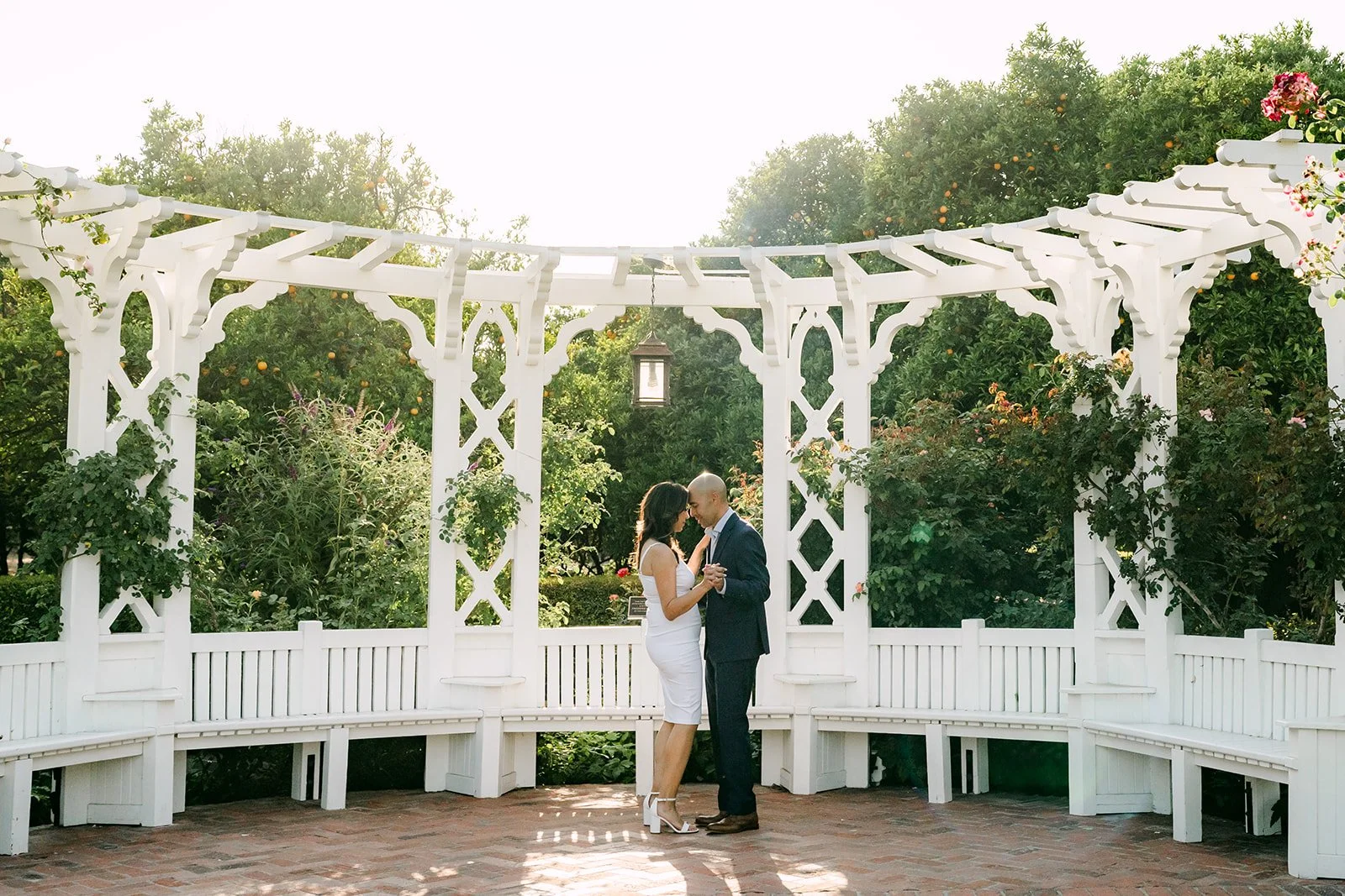 Wide view of the white gazebo with Francesca and Daniel standing at its center.