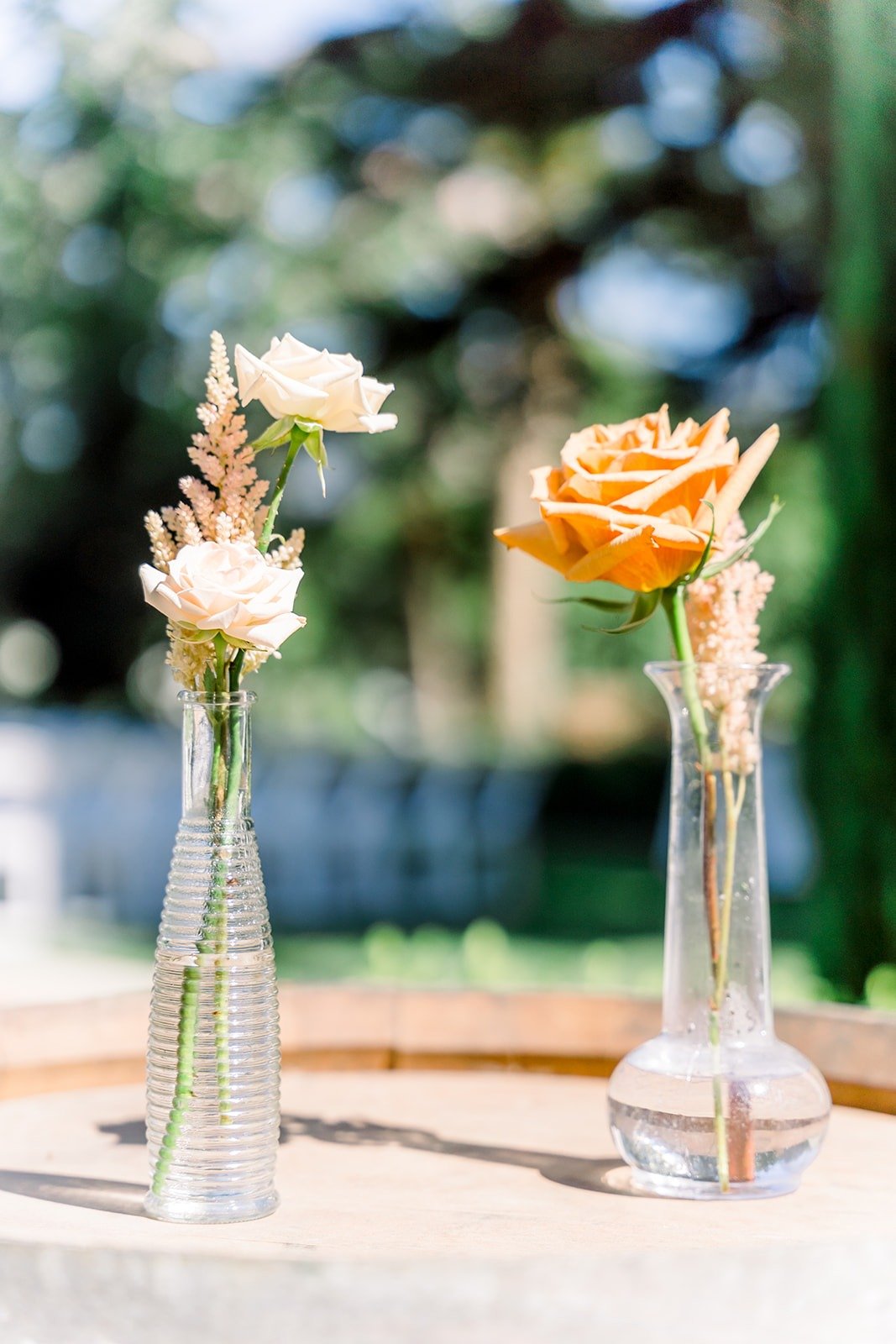 Single orange and white blooms in bud vases at the ceremony