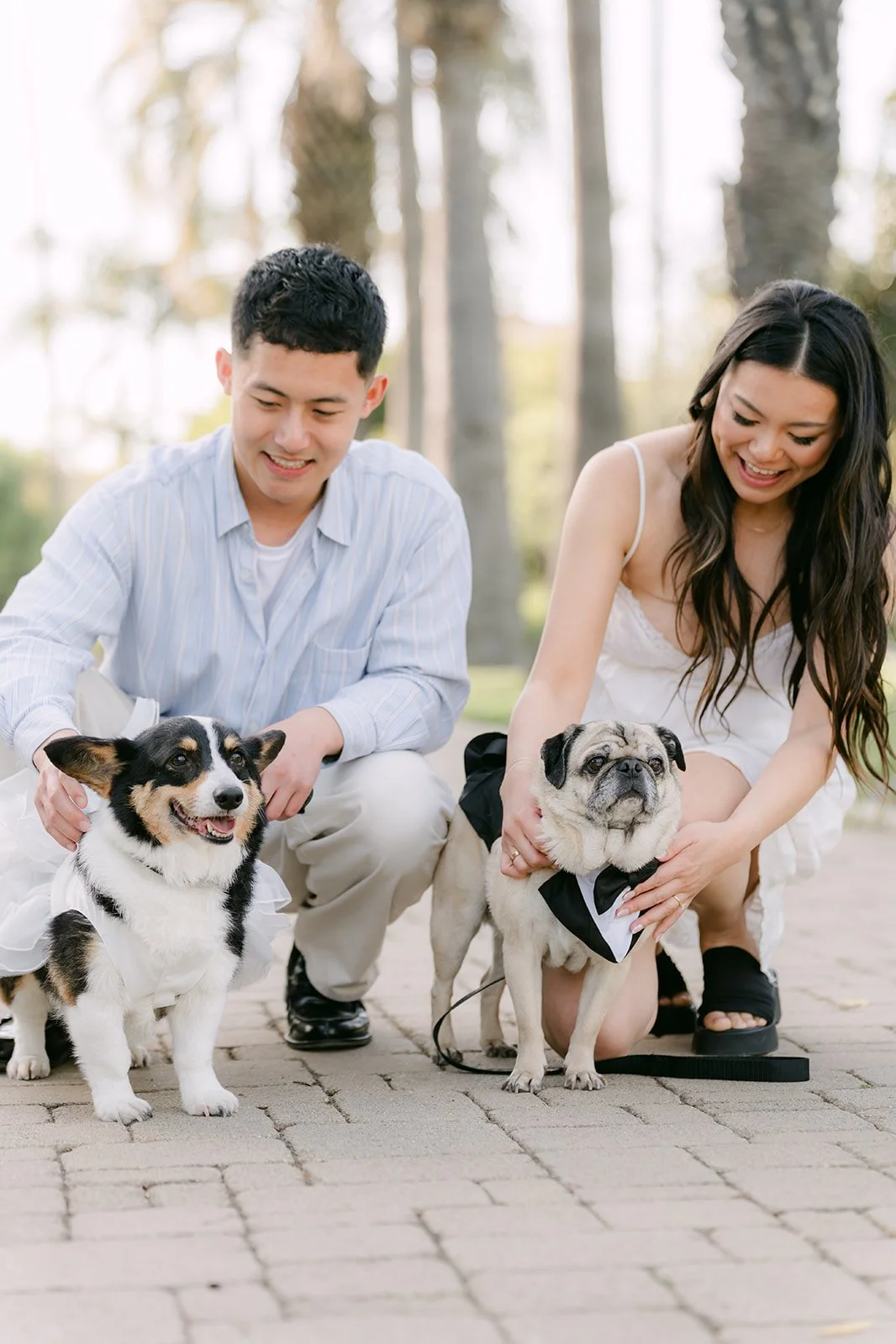 Jadee and Richard each hold one of their dogs and smile at the camera.