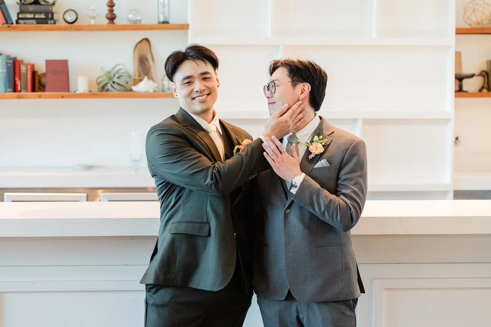 Groomsman squishing Alex's cheeks