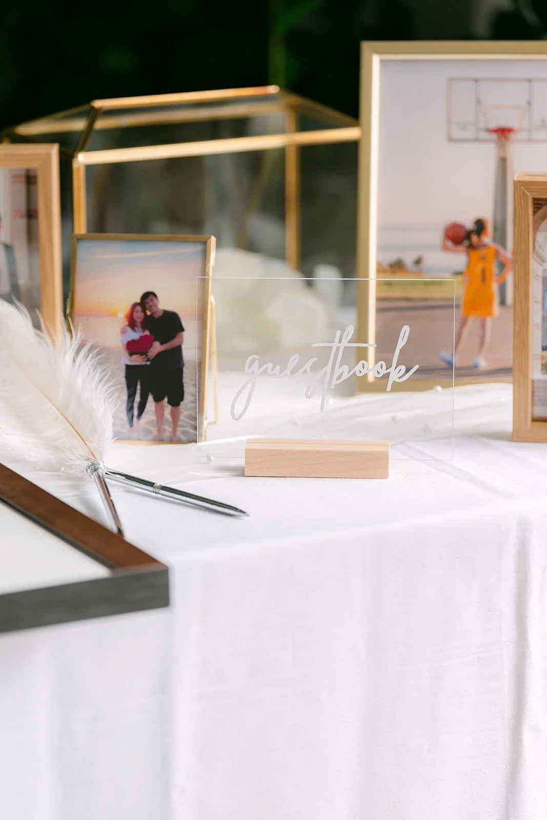 The homemade welcome table with framed photos of Angela and Eli and a feather pen