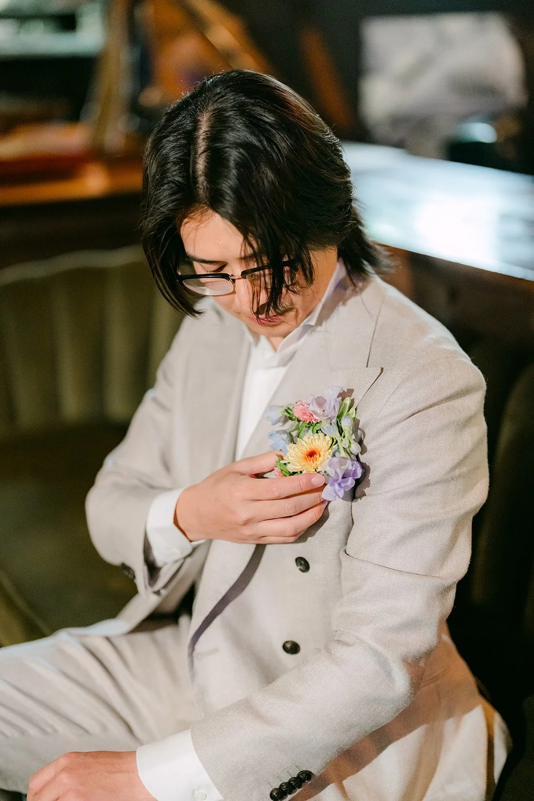Groom pinning on his pastel boutonniere
