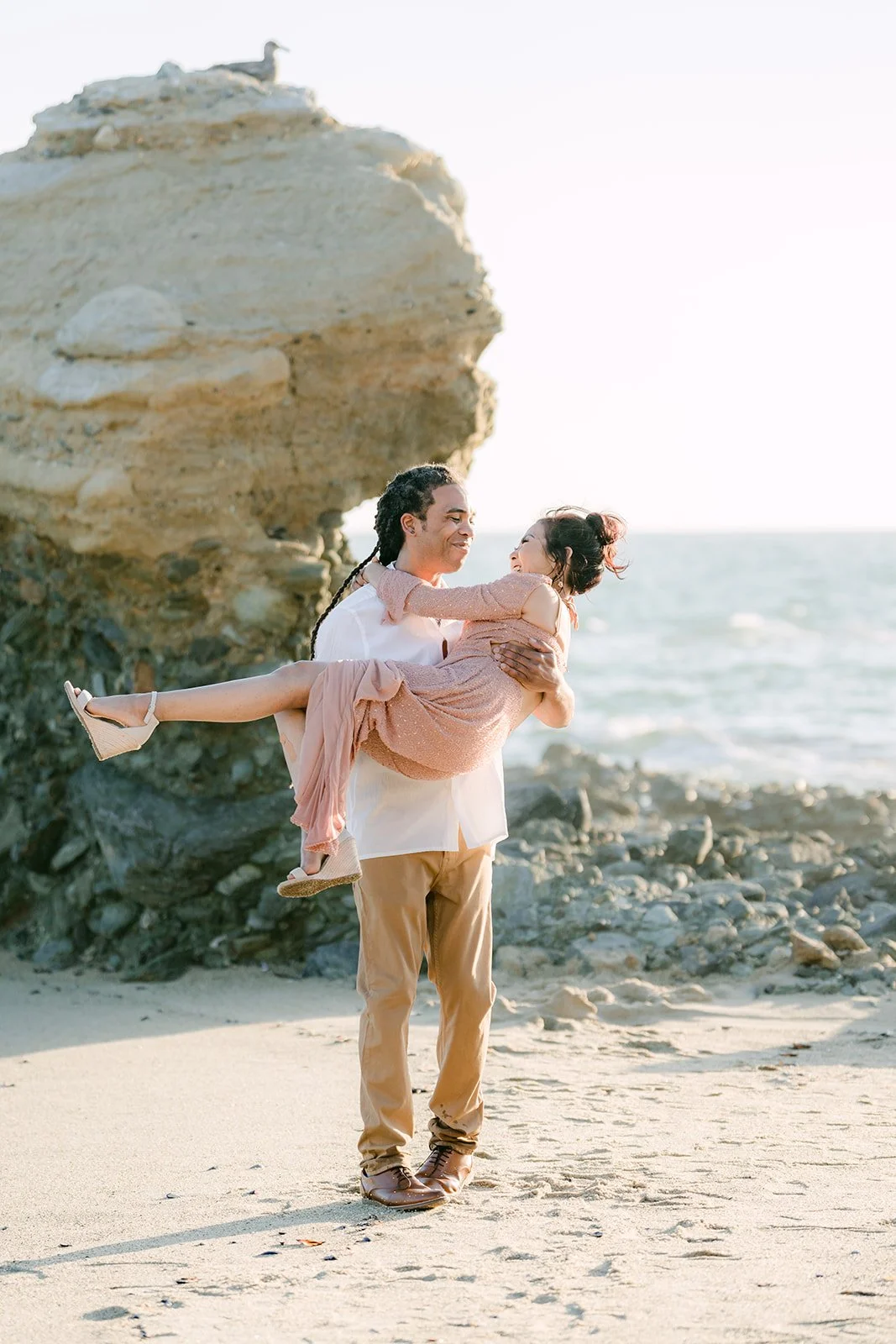 Michael lifting Amy in front of the rock.
