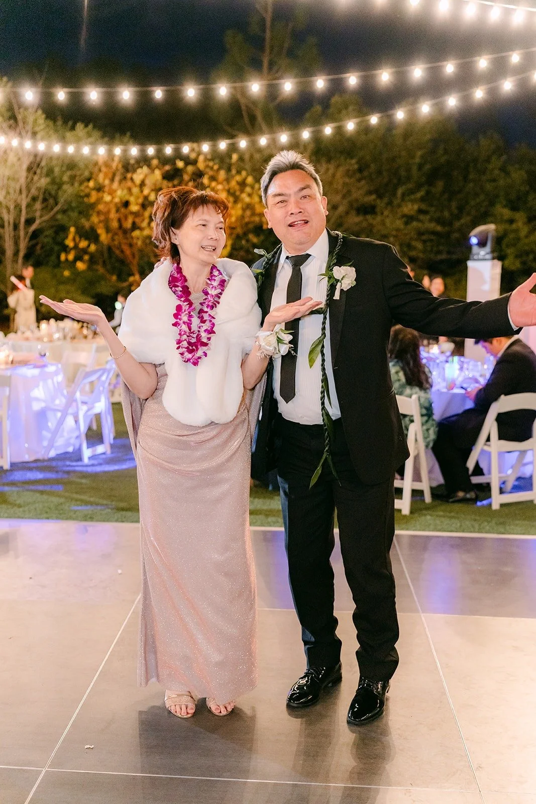 Two guests in leis dancing together on the dance floor