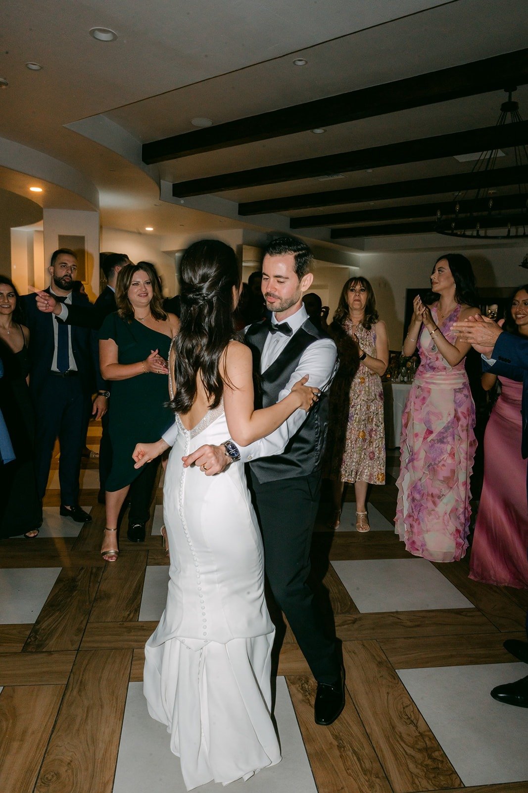 Stephanie and Kevin dancing as guests circle the dance floor