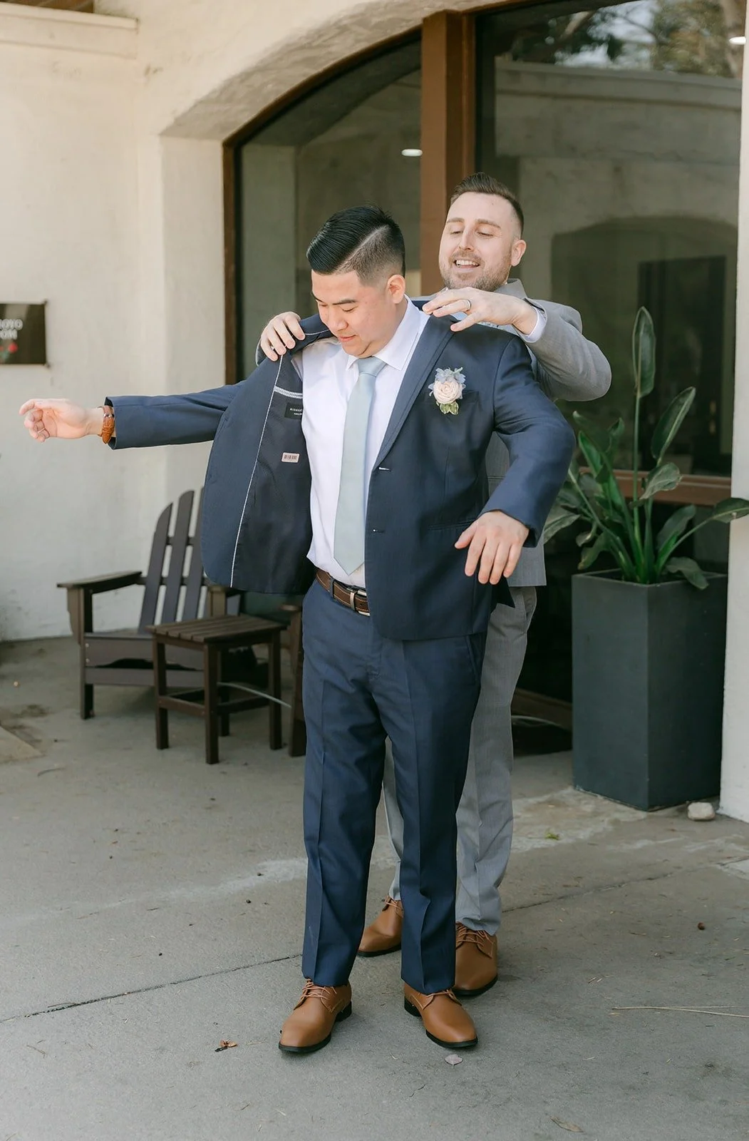 Jordan getting a hand with his navy suit jacket