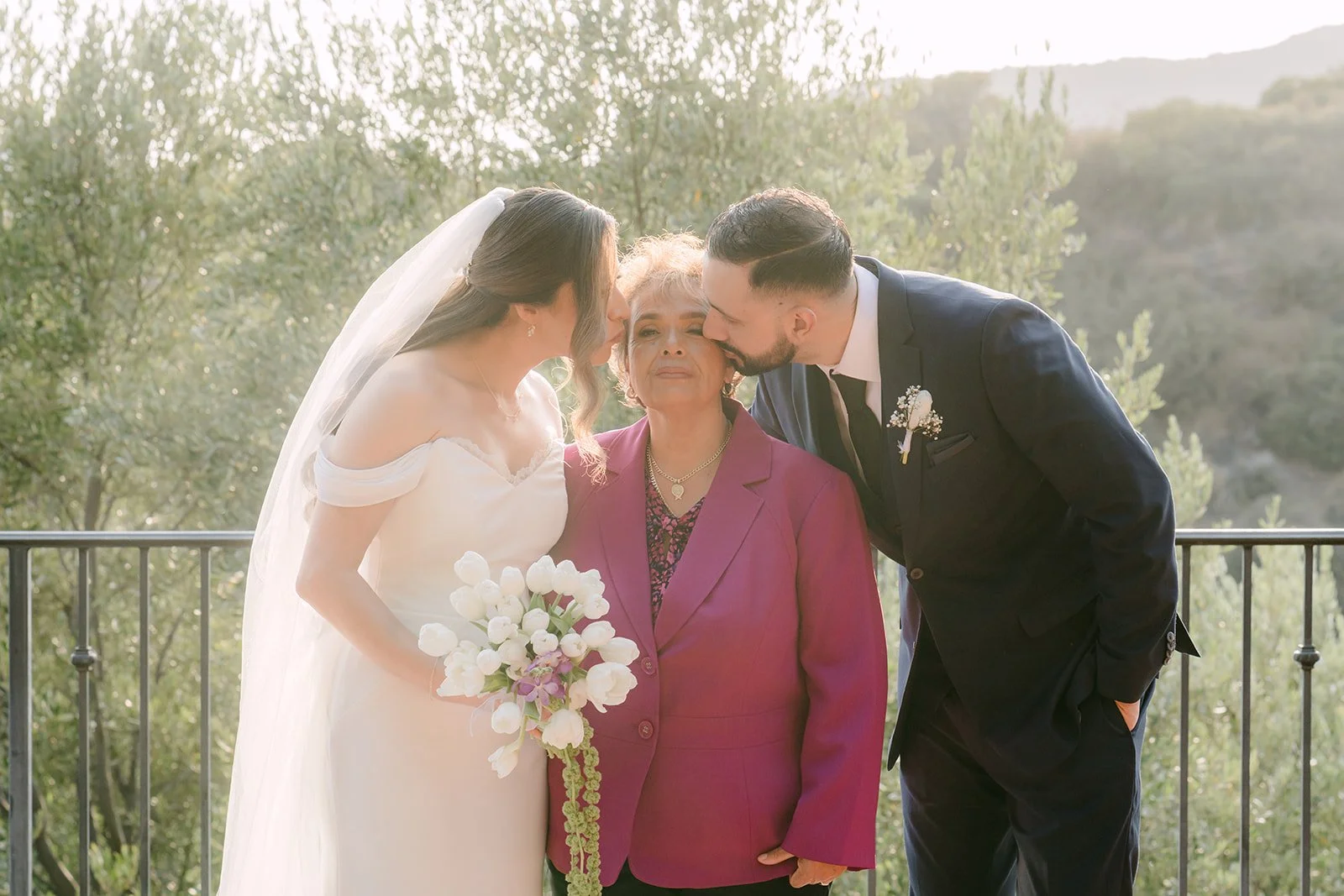 Danny kissing his mom's cheek as Mariana smiles beside them, photographed by One and Only Production