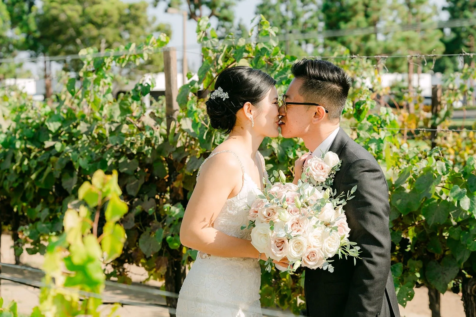 Xuemin and Alex sharing a kiss after their first look in the vineyard