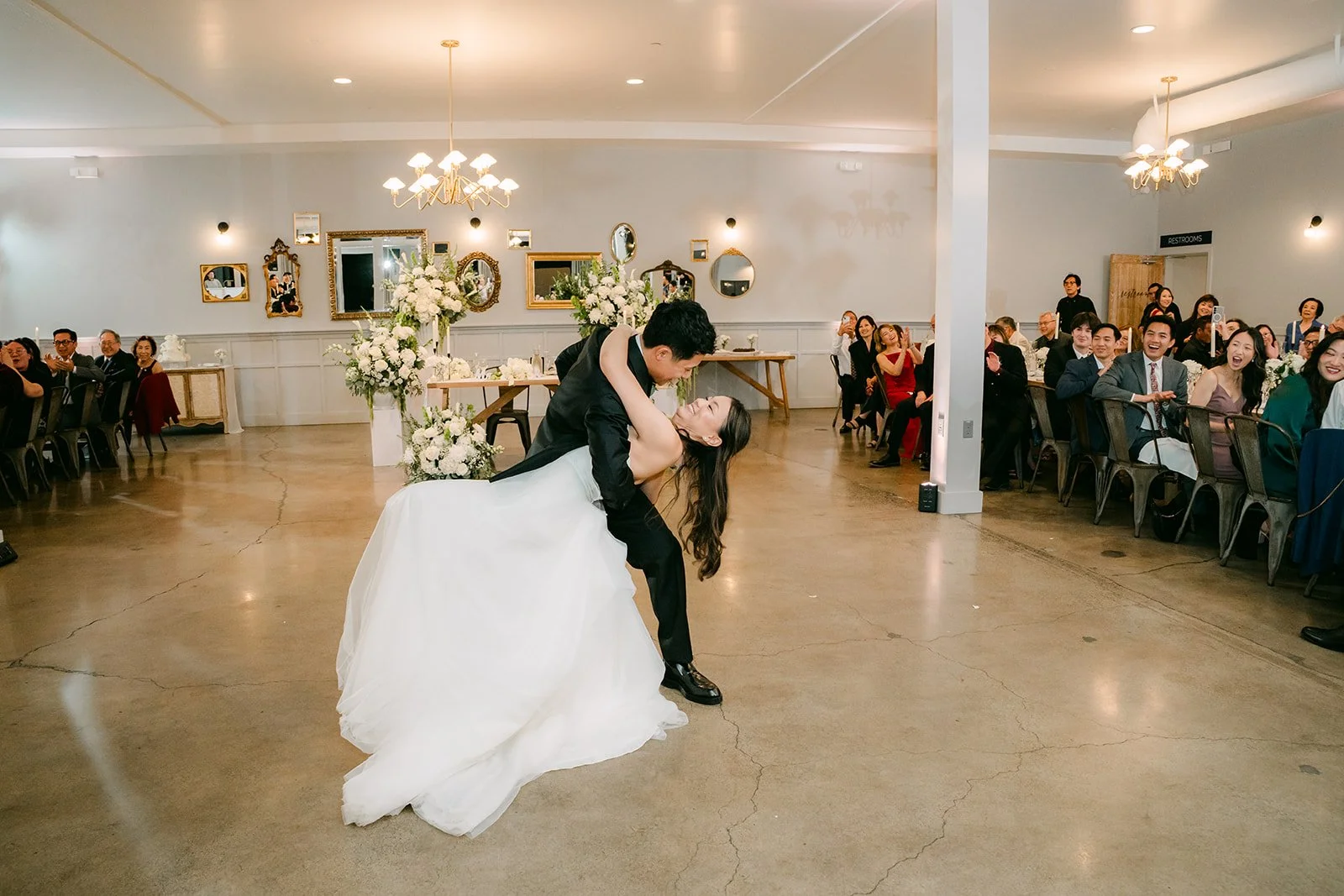 First dance in the reception room with guests watching