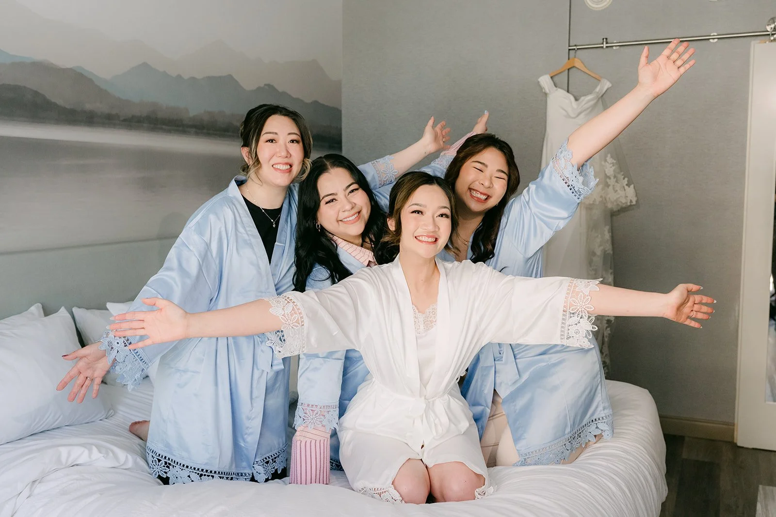 Amanda and her bridesmaids cheering on the sofa in their robes.