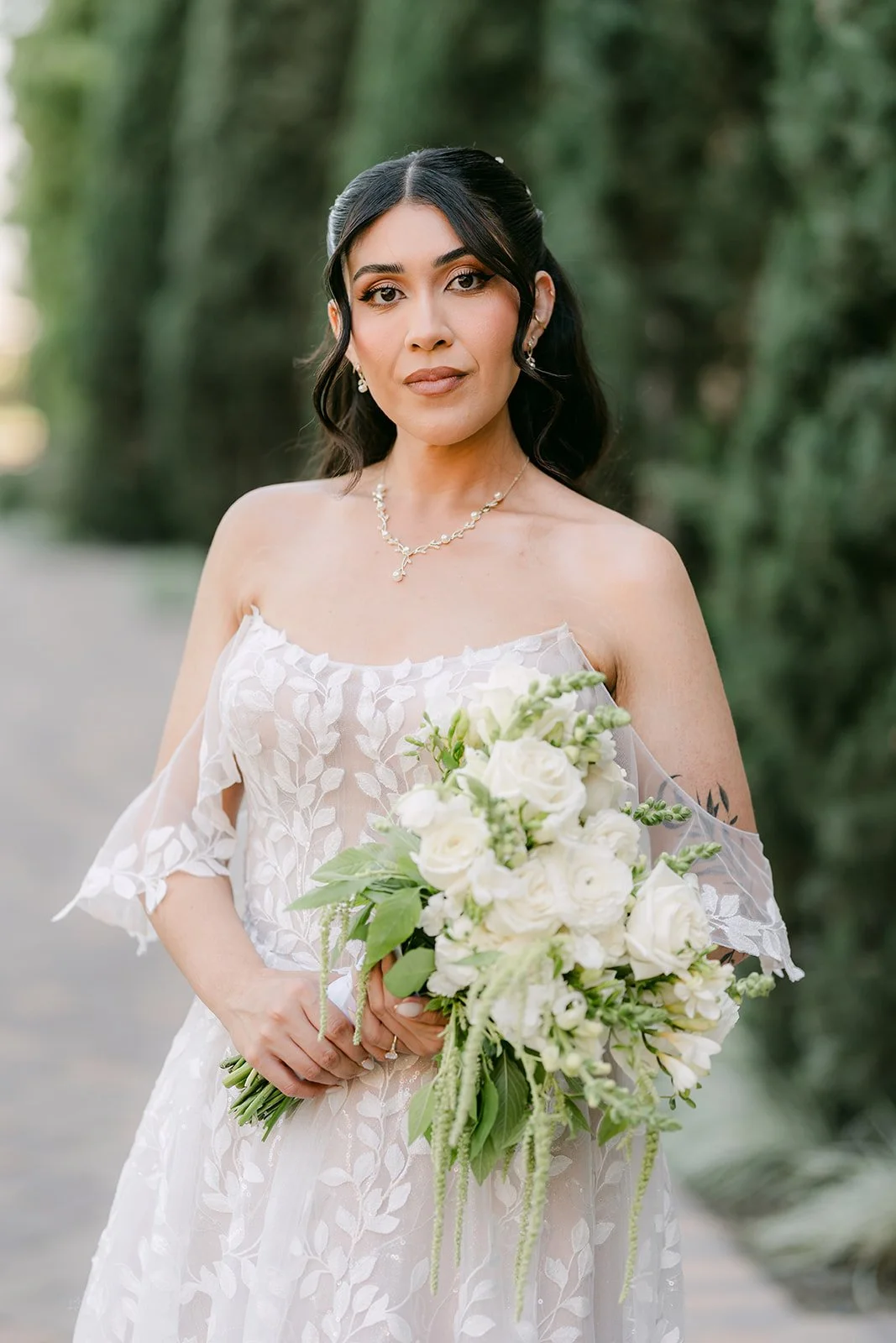 Fernanda in her lace gown holding a white bouquet.