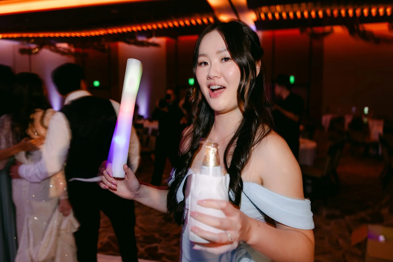 Guest dancing with a glow stick at the reception