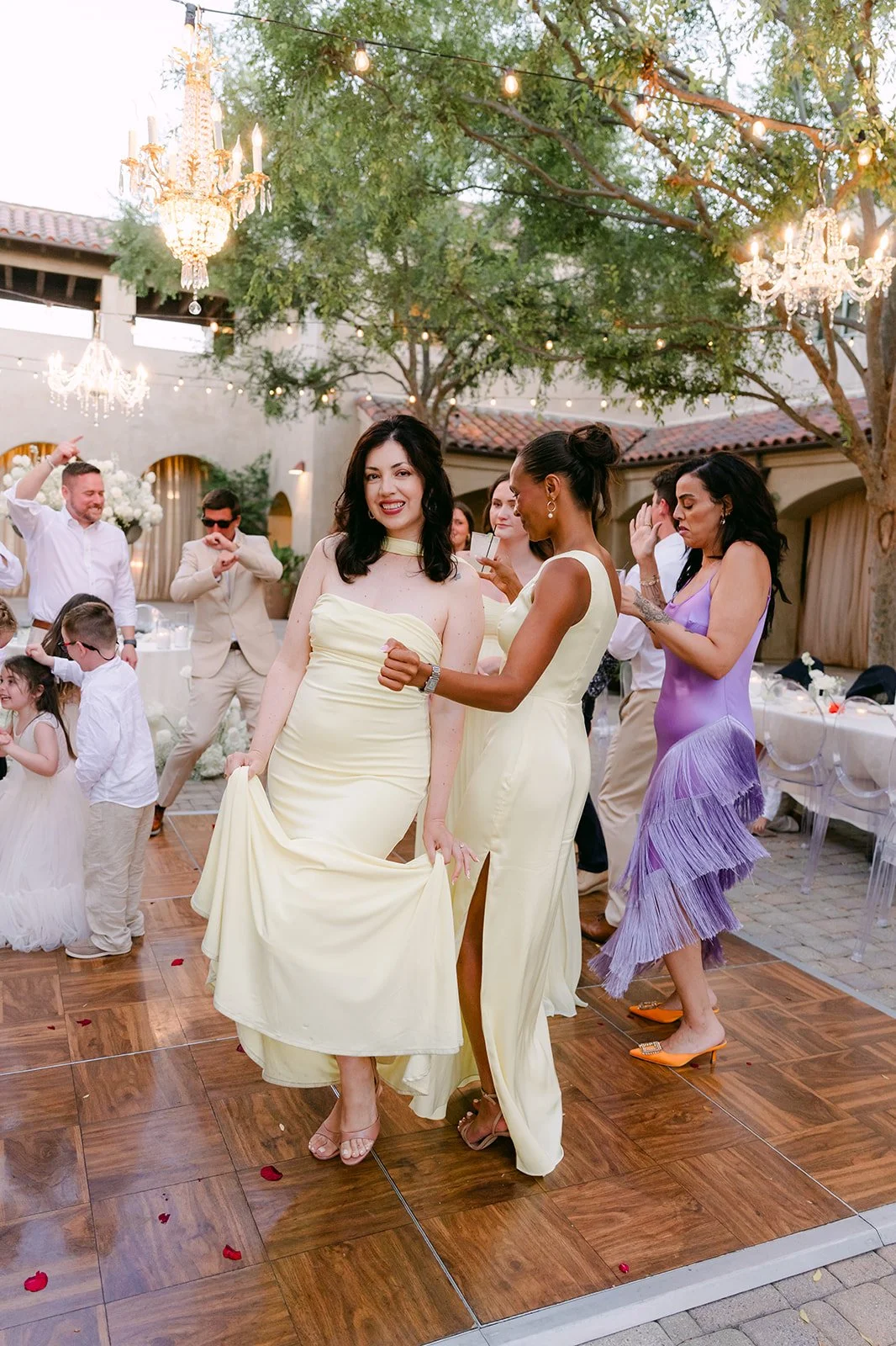 Bridesmaids dancing together on the wood dance floor