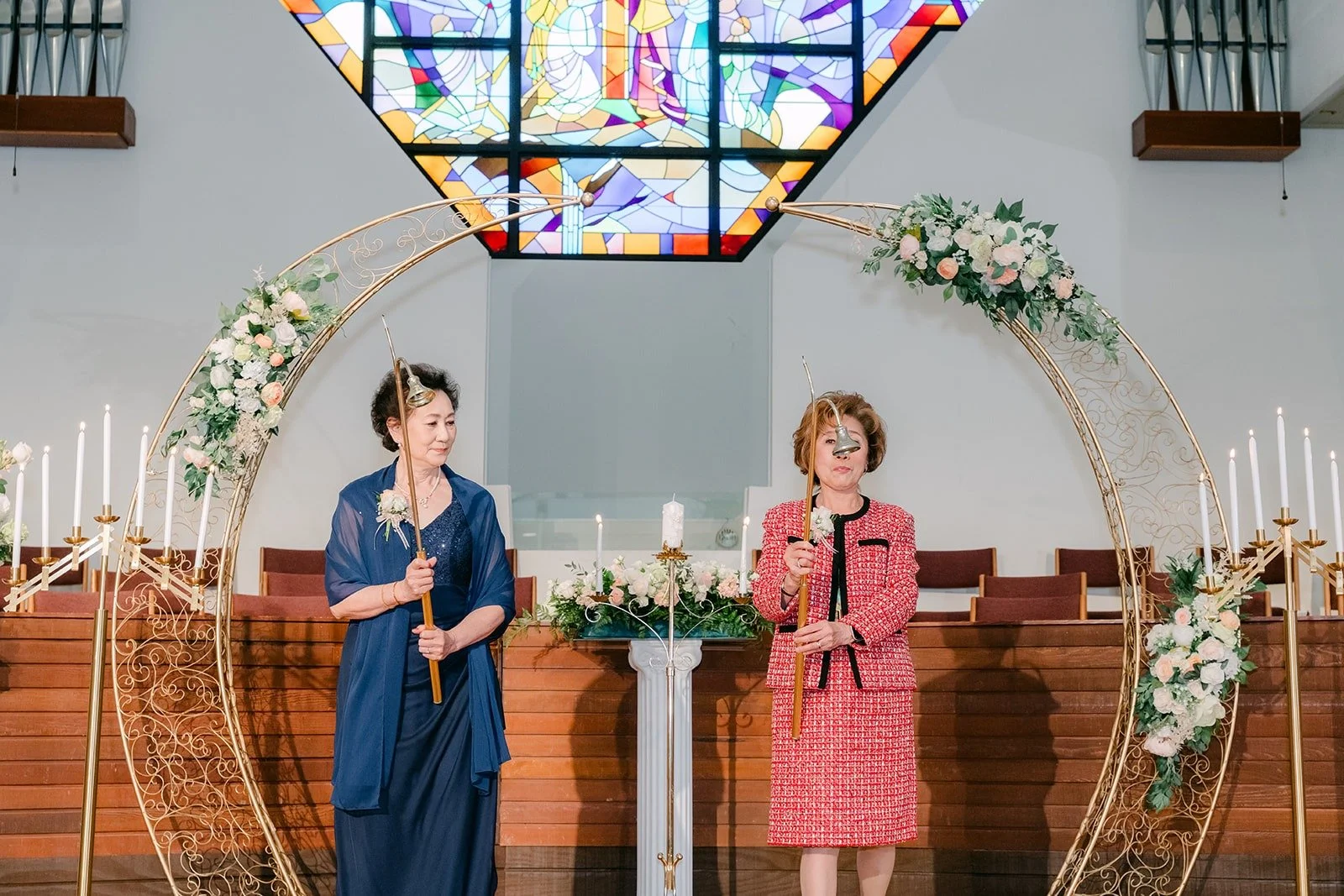 Both mothers stand at the altar after lighting the candles