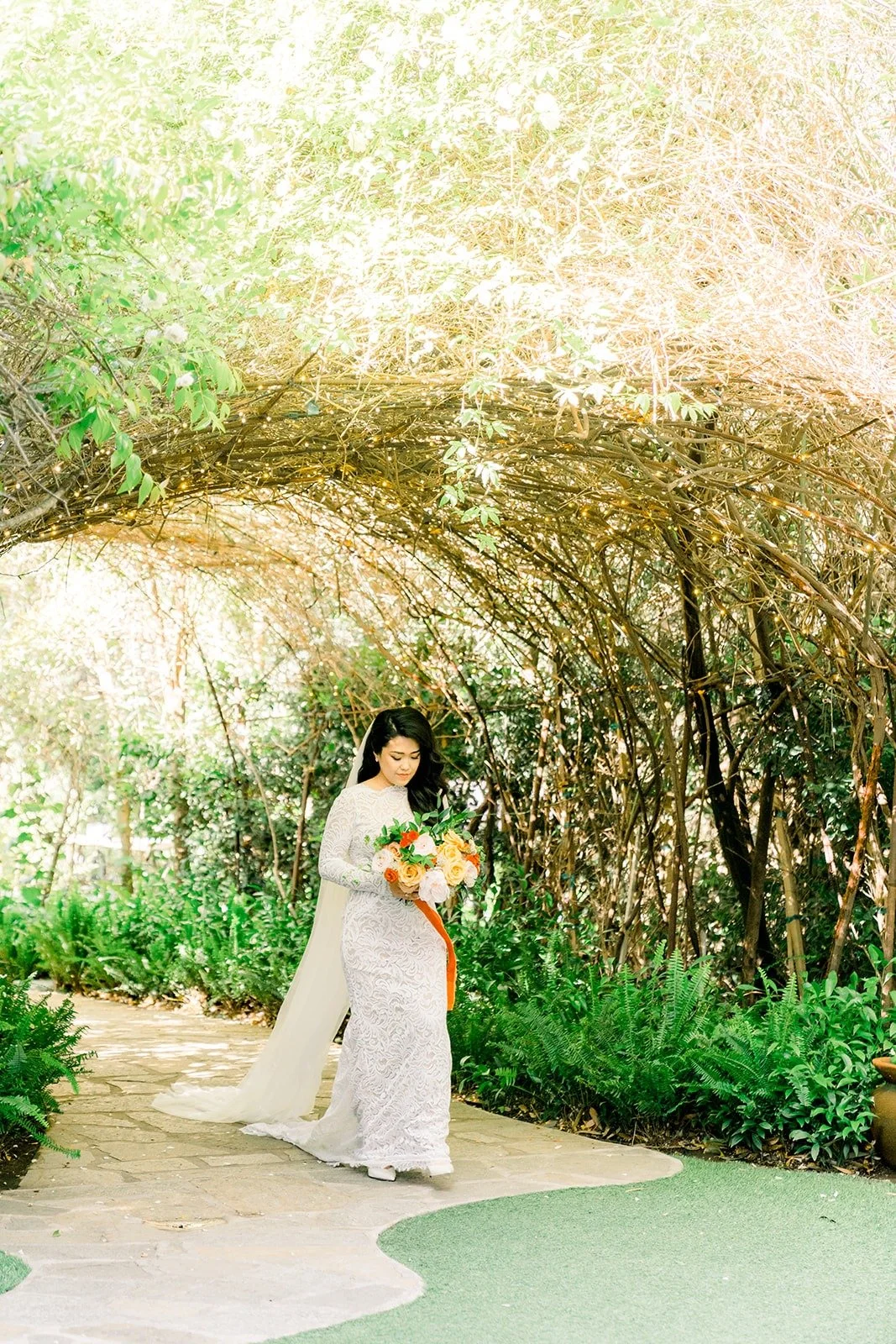 Hannah walking down the stone path toward the ceremony