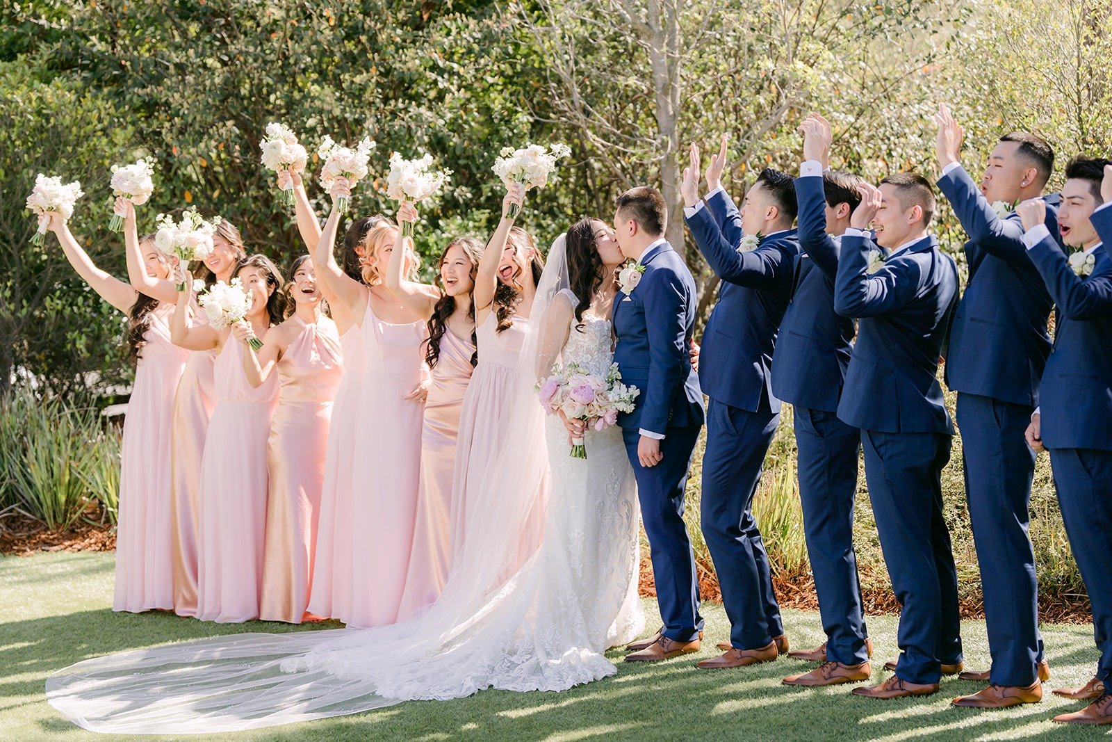 Kelli and Alex's wedding party cheering with bouquets in the air at Los Robles Greens