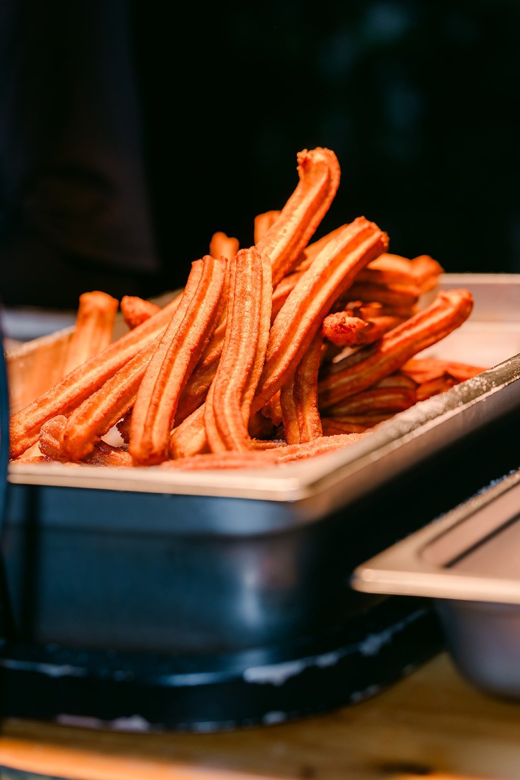 Fresh churros piled in a tray at the Churro Champ cart, photographed by One and Only Production
