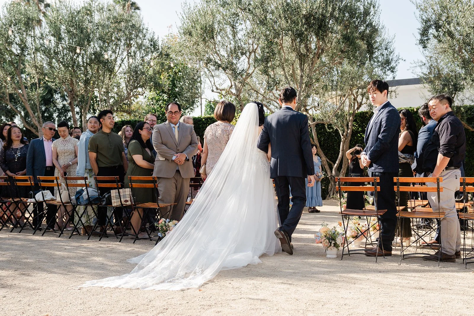 Constance walking down the aisle with her dad in the Olive Grove