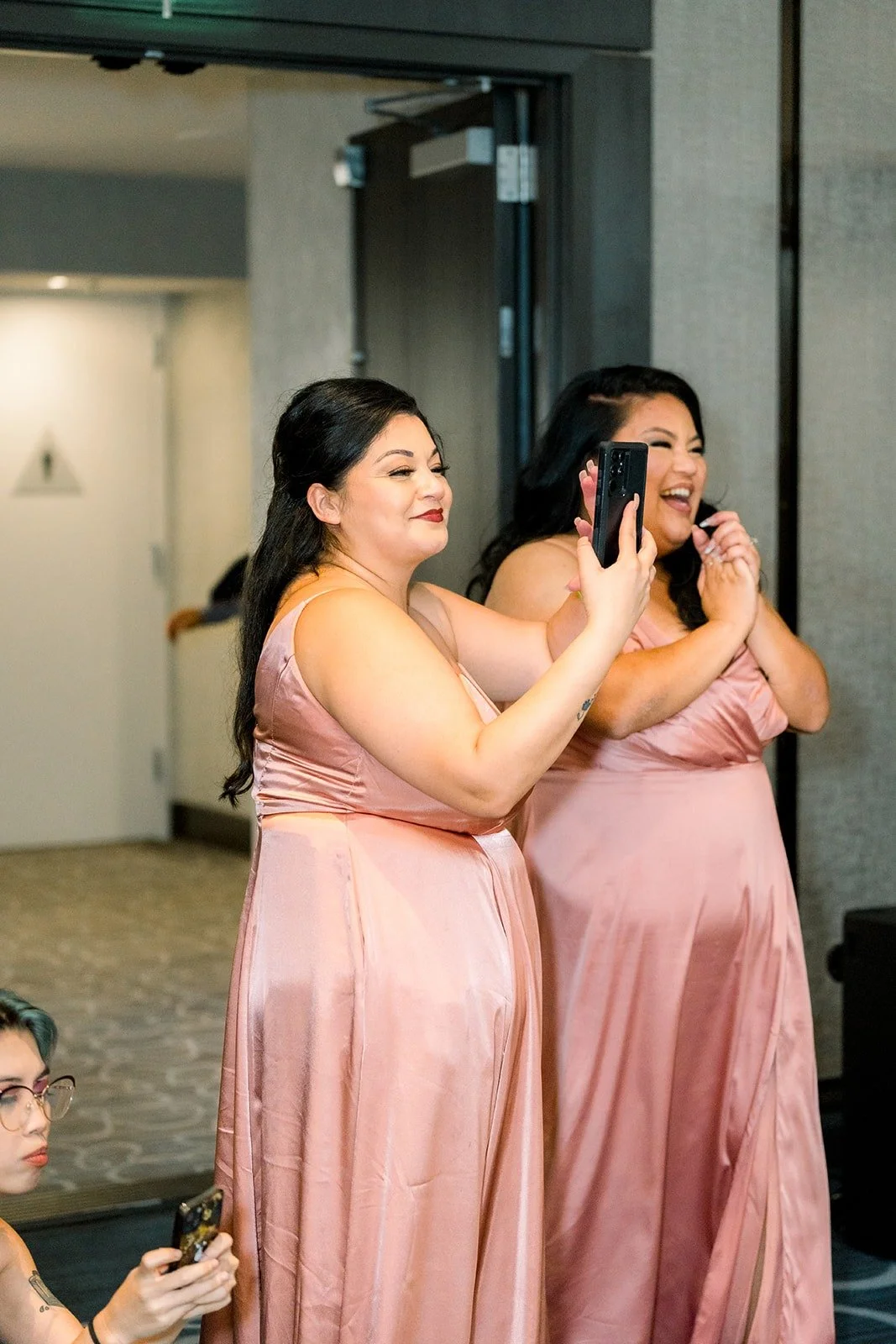 Two bridesmaids in dusty rose share a speech