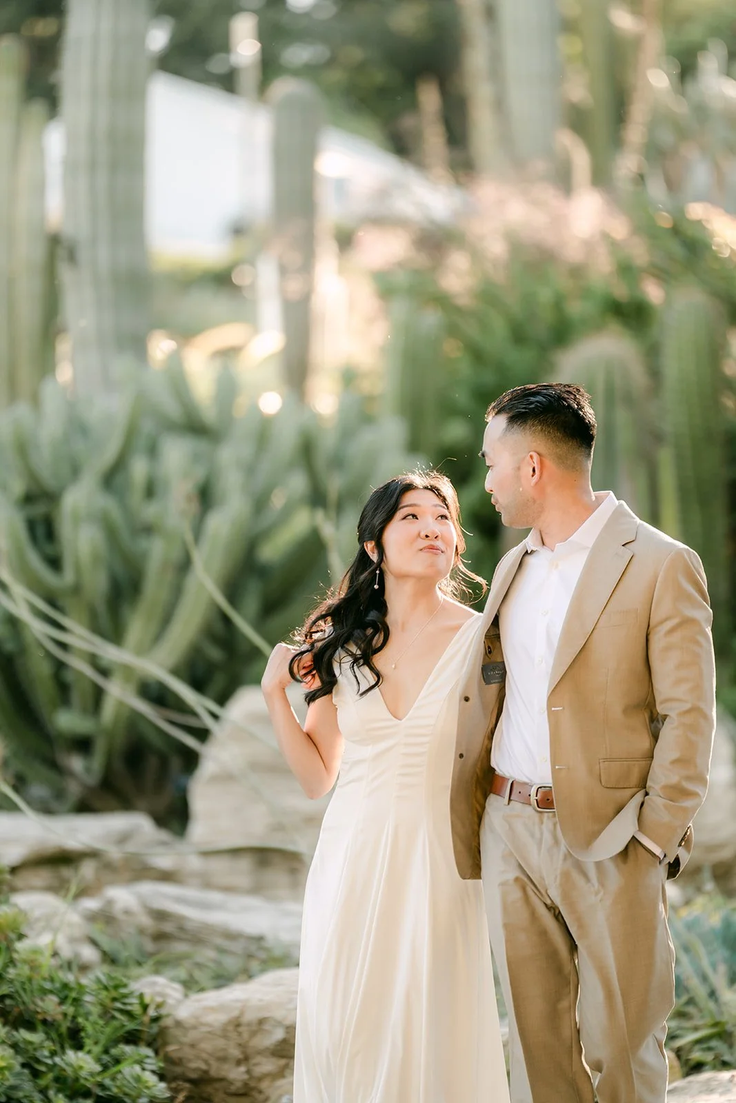 Kim and Vincent smiling together among the cacti in warm light.