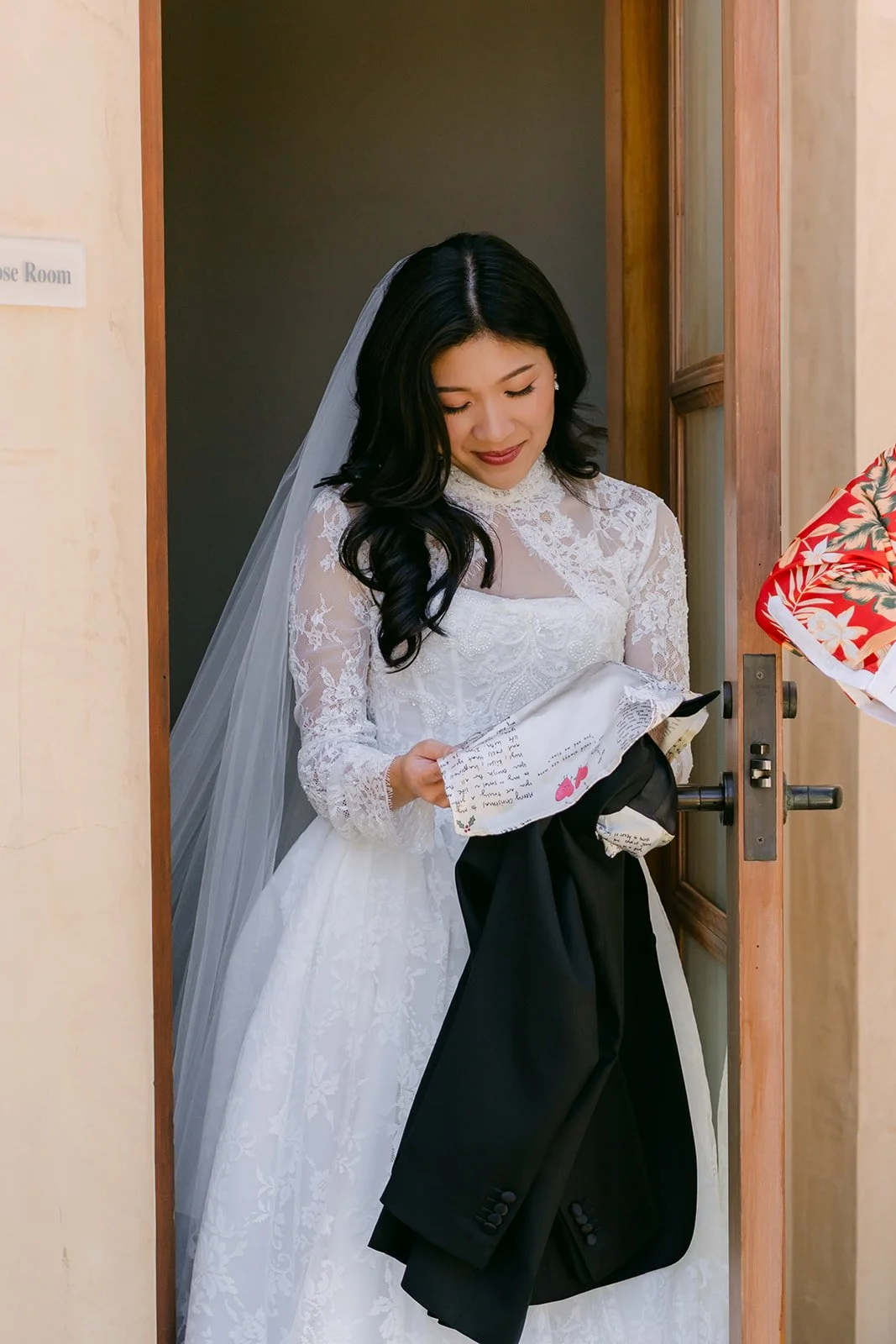 Kim at the bridal suite door holding Vincent's jacket